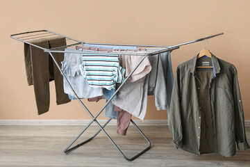 Dryer with clean clothes near color wall