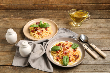 Plates with tasty pasta carbonara on wooden background