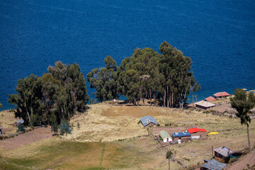 A breathtaking view of Lake Titicaca unfolds from the heights of Taquille Island, where the deep blue of the water meets the vast Andean sky.
