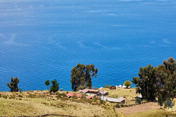 A breathtaking view of Lake Titicaca unfolds from the heights of Taquille Island, where the deep blue of the water meets the vast Andean sky.

