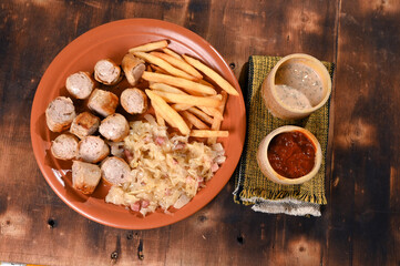 plate for food French fries sausage white sausage and sauerkraut herb sauce and ketchup typical German food taste