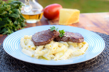 penne pasta with red bolognese sauce, typical Italian cuisine with filet mignon
