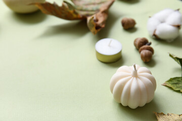Composition with candles and autumn decor on color background, closeup