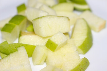 Green Apple Slices with Blurred Background. Close-up of Cut Green Apple. Chopped Green Apple with selective focus.