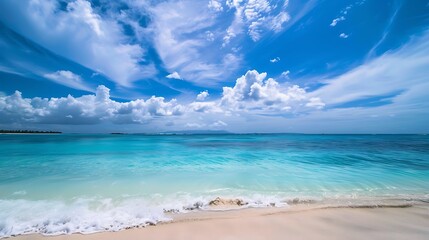 Turquoise Ocean Water Washing Sandy Shore Under Bright Blue Sky With White Clouds