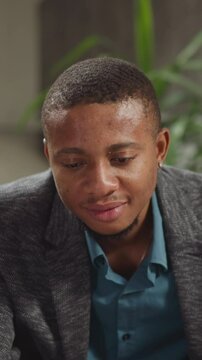 Smiling black guy tutor supports attentive junior schoolboy at private English lesson with native speaker in living room closeup slow motion