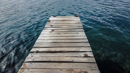 Fototapeta premium Wooden Pier Extending Over Calm Blue Water Under Sunny Skies
