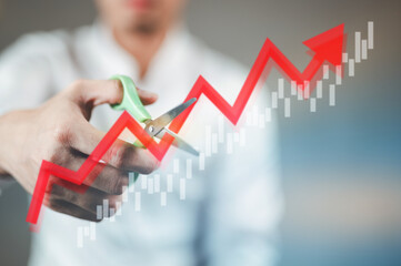 Businessman uses scissors to cut a stock market graph