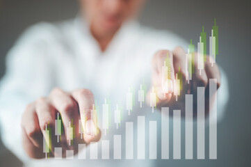 A businessman in a white shirt is tapping on an uptrend stock chart.