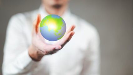 A man wearing a white shirt is holding a 3D globe.