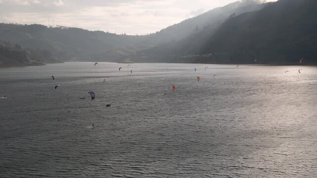 vista aerea del lago calima en colombia lleno de cometas de kitesurf al atardecer