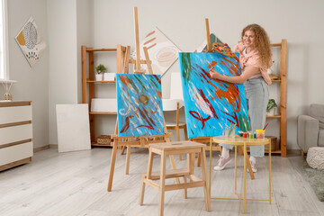 Female artist painting on canvas in workshop