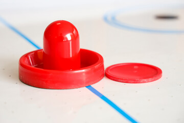 Air hockey mallet with puck on table, closeup