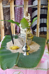 Preparing Pongal rice. tamil silver pot on rice and a coconut on top for tamil new year.Using a...
