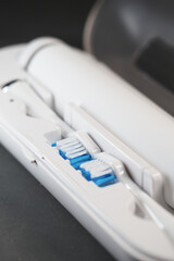 Electric toothbrush charging on a counter in a dimly lit bathroom