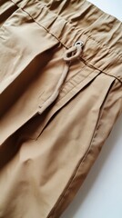 Close up of khaki pants with drawstring waist and pocket detail studio shot fashion apparel