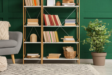 Shelving unit with books and decor near green wall in room