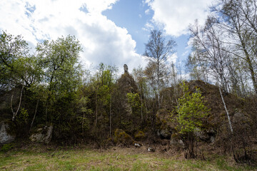 Obraz premium A picturesque view of a serene landscape featuring vibrant greenery, unique rock formations, and a partly cloudy sky, perfect for nature lovers and landscape photography enthusiasts.