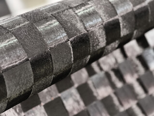 Exploring the intricate beauty of woven carbon fiber cloth in a creative design workspace