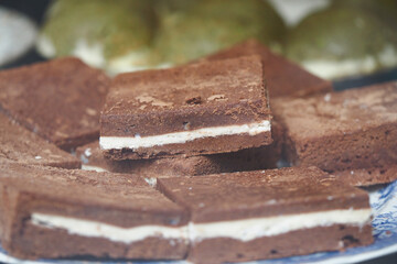 Chocolate dessert squares with creamy filling displayed at bakery
