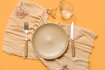 Beautiful table setting with gypsophila flowers on orange background