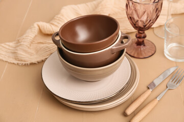 Stack of clean dishes on beige wooden background