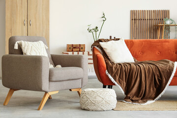 Interior of living room with comfortable brown sofa, table and armchair