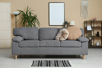 Interior of light living room with sofa near beige wall