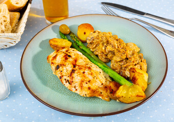Healthy dinner of baked chicken breast fillet with mushrooms and vegetable garnish