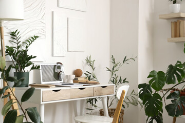 Interior of room with comfortable workplace near white wall