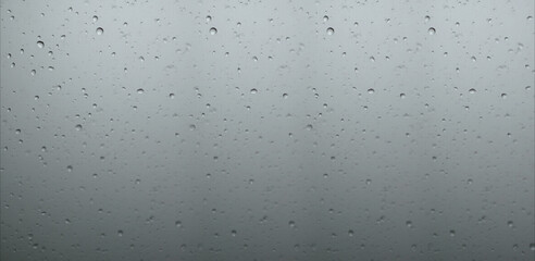 The concept of raindrops falling on a gray background. Water drops on white background texture. backdrop glass covered with drops of water. gray bubbles in water