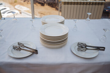 The beautifully arranged table is adorned with a variety of plates, service tongs, and elegant wine...