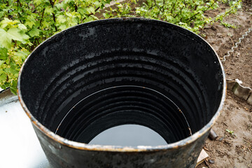 This highly durable black barrel boasts a central circular hole, making it perfect for a range of uses, especially in gardening, efficient waste management, and composting practices