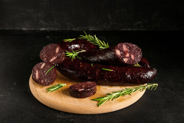 Tasty blood sausage on black background