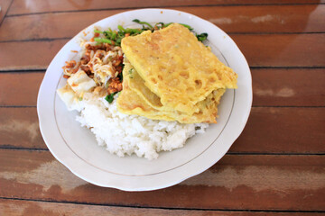 a plate of rice with pecel
