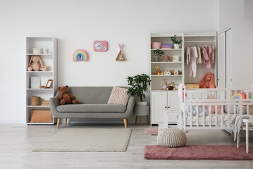 Interior of nursery with baby crib, closet and sofa