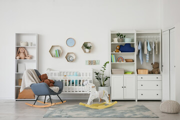 Interior of nursery with baby crib, closet and rocking armchair