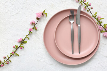 Beautiful table setting with pink blooming branches on white background