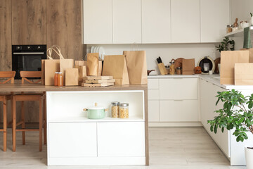 Paper bags with juice on table in kitchen interior. Food delivery service