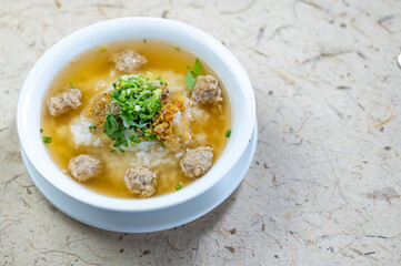 Fresh homemade meatball soup served in a white bowl with green herbs and broth on a light textured surface for comforting and hearty meal presentation