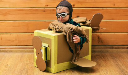Kid play with imagined wings. Imaginative child dreams of flying. Cardboard wings spark imagination...