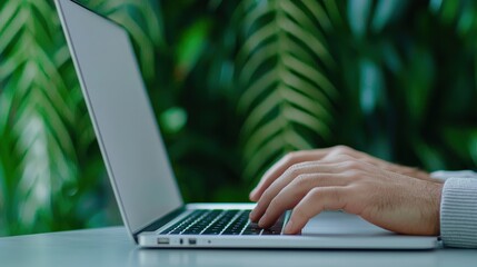 Fototapeta premium Freelancer working remotely on laptop in lush green environment