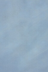 A textured surface in a light blue or pale grey-blue hue features subtle variations and brushstroke-like patterns, creating an abstract background
