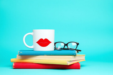 Naklejka premium cup of coffee sitting on top of a stack of books