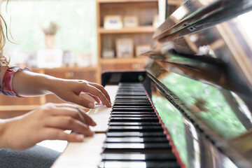 Girl learn to play piano. woman hand playing piano .