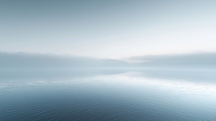 Fototapeta premium Tranquil morning at a misty lake surrounded by soft hills and calm waters