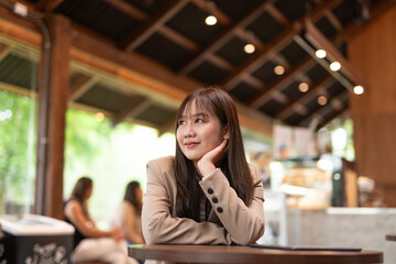 young woman in cafe thinking and looking through window