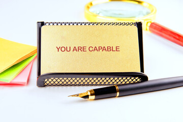 Business capable or incapable concept. Copy space. Motivational words YOU ARE CAPABLE on a gold...