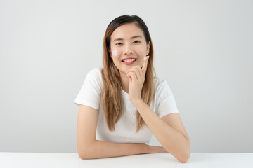Beautiful Asian woman smile use cream for good skin. face of a healthy woman apply cream and...