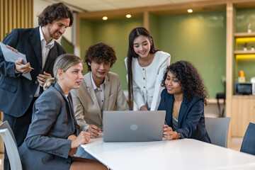 Obraz premium Diverse business team meeting and discussing marketing research and strategy using laptop, collaboration and communication planning, analysis, brainstorming for innovation, productivity, leadership